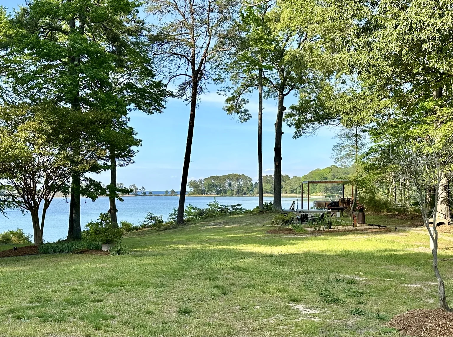 Backyard lawn at Vista Cove overlooking the water and pergola