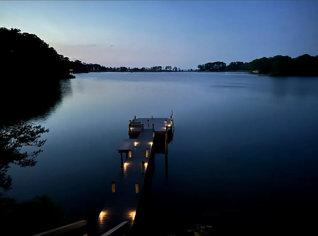 Private dock lights glowing over calm water at twilight