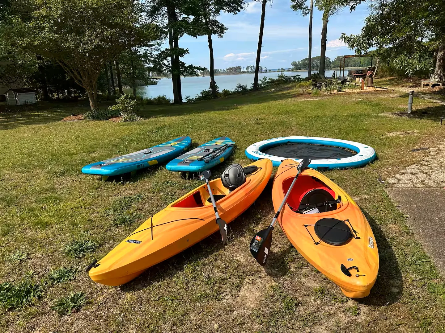 Kayaks, paddle boards, and floating hammock ready for days on the water