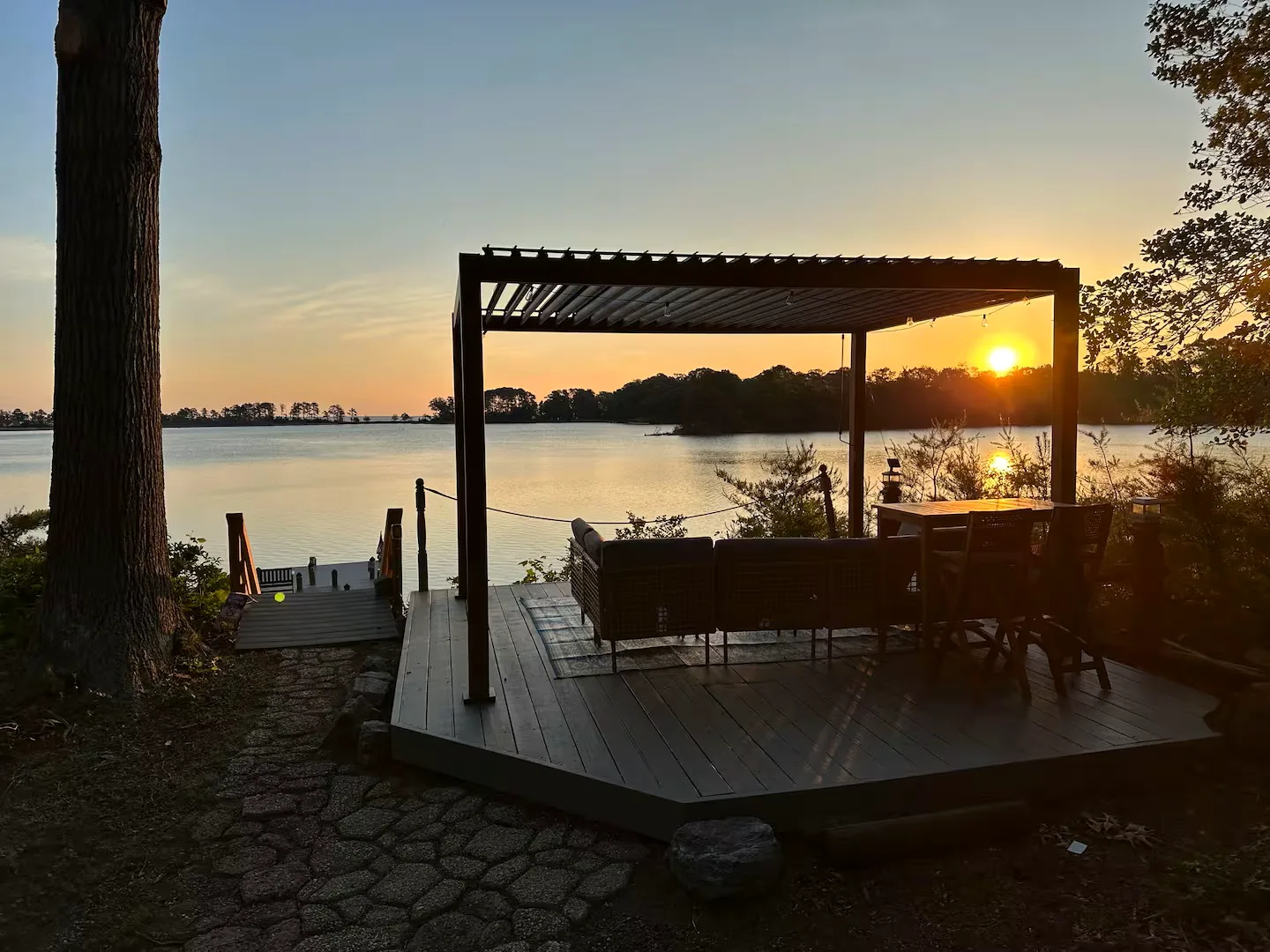 Sunrise glowing behind the waterfront pergola at Vista Cove